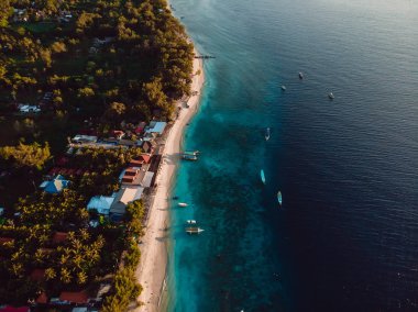 Plajı, teknesi ve okyanusu olan tropik Gili adası. Hava görünümü.