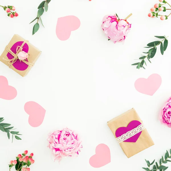Рамка з рожевих квітів та гілок евкаліпта та подарунків на білому — стокове фото