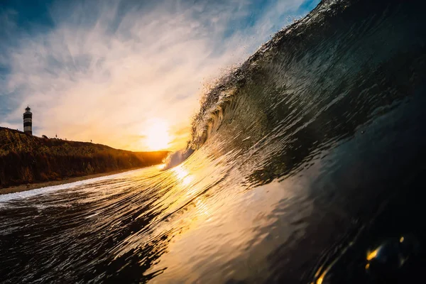 Wave in sea at sunrise. Barrel wave with warm sunrise colors and — 스톡 사진