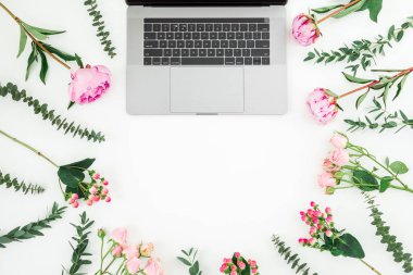 Laptop ve çiçekler beyaz arka planda. Üst Manzara. Düz yatıyordu