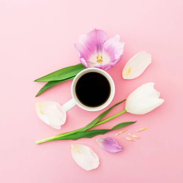 Composición con flores, pétalos y taza de café negro sobre rosa — Foto de Stock