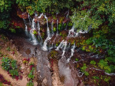 Tropikal ormanda kızıl kayayla inanılmaz bir şelale. Hava görünümü