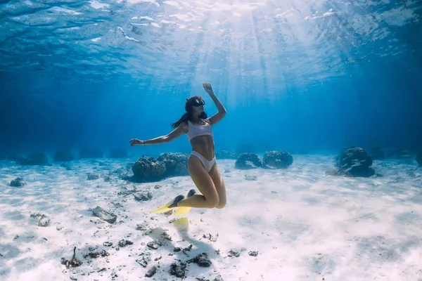 在蓝色的海洋里 有鳍的自由女孩滑翔在沙质的海底 — 图库照片