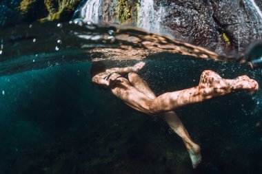 16 Kasım 2019. Bali, Endonezya. Şeffaf nehirde şelaleyle poz veren kadınlar.