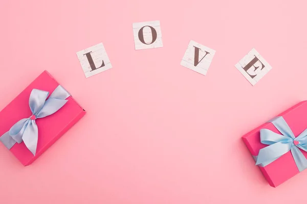 Valentines day concept with love word and gifts on pink. Flat la — 스톡 사진