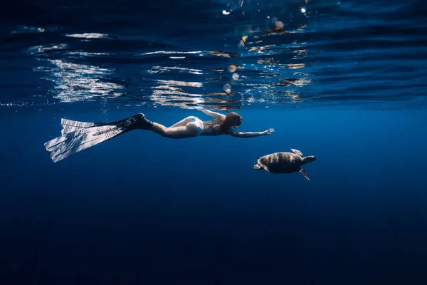 Freediver com barbatanas desliza debaixo d 'água com tartaruga no oceano. Snor... — Fotografia de Stock