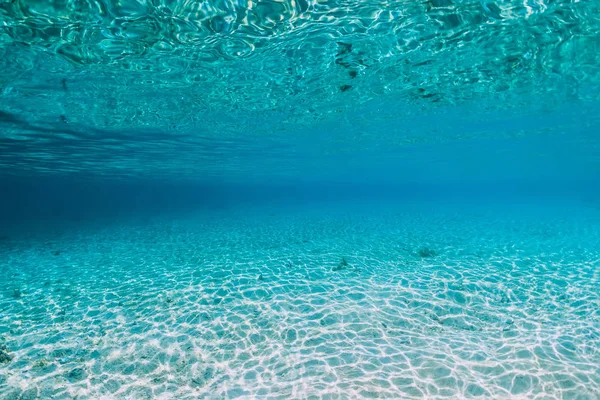 Água do oceano azul tropical com fundo arenoso subaquático — Fotografia de Stock