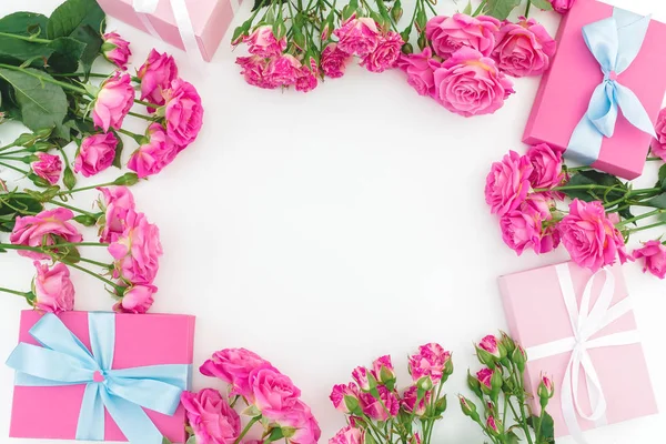 Blomsterramme med lyserøde roser blomster og gave på hvid backgroun - Stock-foto