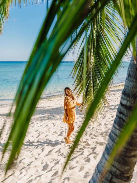 Mujer joven en vestido relajante en la playa de palmeras tropicales. Tropical v — Foto de Stock