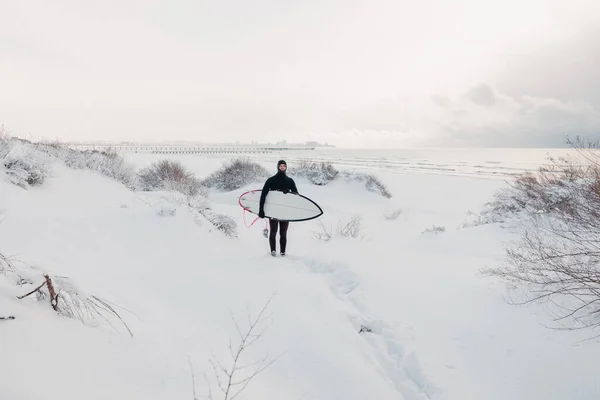 Cold winter and surfer with surfboard. Snowy day with surfer in — 스톡 사진