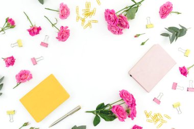 Üzerinde defter, okaliptüs, hediye ve güller olan çerçeve.