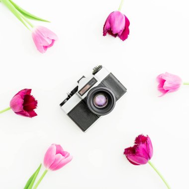 Beyaz arka planda izole edilmiş eski bir kamera ve çiçekler. Düz yatıyordu. Üst görünüm.