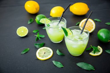 Limonlu ve limonlu limonlu ferahlatıcı bir içecek. Koyu arkaplanda buzlu limonata
