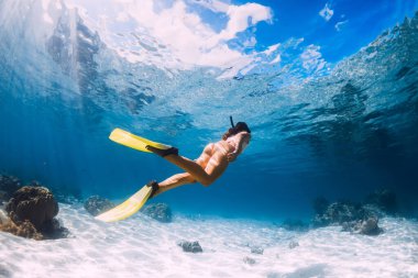Mavi okyanusta yüzen serbest yüzücü bir kadın. Mauritius 'ta serbest dalış ya da şnorkelle yüzme