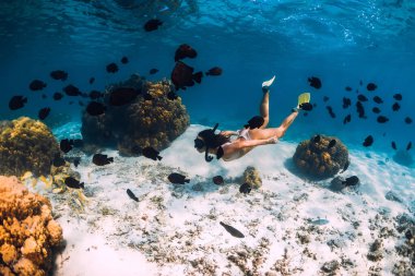 Mavi okyanusta yüzen serbest yüzücü bir kadın. Mauritius 'ta serbest dalış ya da şnorkelle yüzme