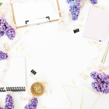 Pano, defter, leylak çiçekleri ve aksesuarlarla beyaz zemin üzerine uzay kompozisyonu kopyala. Düz yatış, üst görünüm