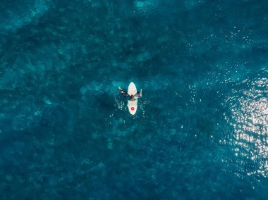 Mavi okyanustaki sörfçülerin hava görüntüsü. Üst Manzara. Tropikal denizde sörf yapmak