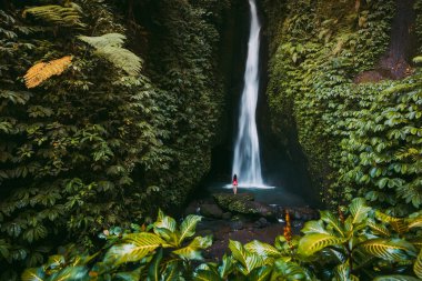 Tropikal ormanda şelale ve bikinili yalnız bir kadın. Endonezya, Bali 'de Leke Leke şelalesi