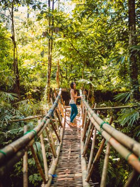 Tropikal ormanda briçte kalan bir kadın. Endonezya, Bali 'de Şelale