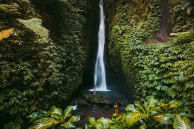 Tropikal ormanda şelale ve bikinili yalnız bir kadın. Endonezya, Bali 'de Leke Leke şelalesi