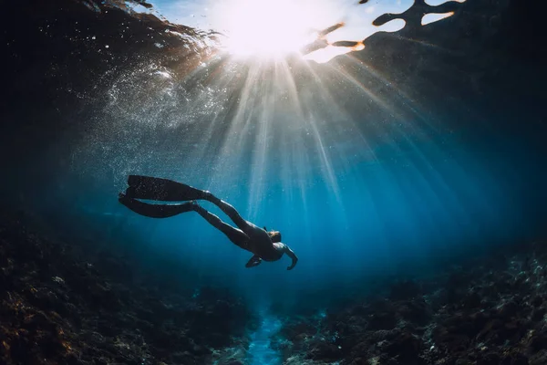 지느러미가 잠수부인 여자는 밑바닥을 미끄러지듯 날아다니며 놀라운 광선을 해저에서의 — 스톡 사진