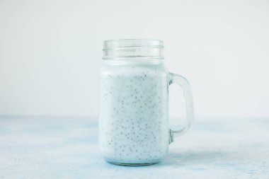 Sağlıklı yaban mersinli yoğurt ya da bardakta chia tohumlu smoothie. Vejetaryen gıda, diyet ve sağlık konsepti