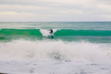 22 Kasım 2019. Kırım, Ukrayna. Dalgıç kıyafetli sörfçü deniz dalgasında sörf tahtasında geziyor..