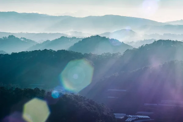 Dağ manzarası boyunca ışık saçar.