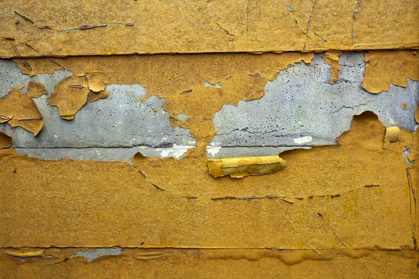 Pared de hormigón con pintura pelada amarilla, naranja vieja textura de fondo brillante áspera agrietada dañada — Foto de Stock