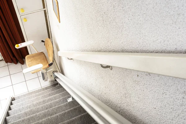 Elevador automático de escaleras en la escalera que lleva a personas mayores y personas con discapacidad de arriba a abajo en una casa —  Fotos de Stock