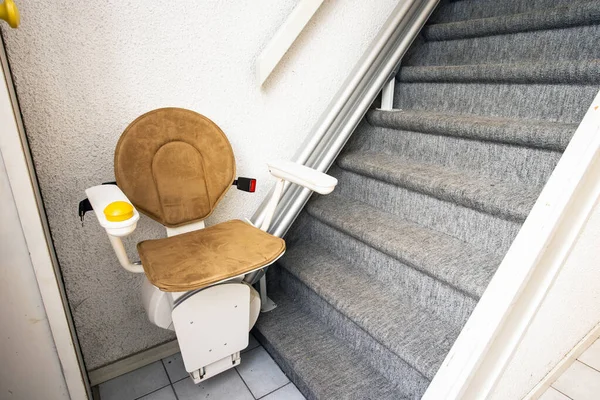 Elevador automático de escaleras en la escalera que lleva a personas mayores y personas con discapacidad de arriba a abajo en una casa —  Fotos de Stock