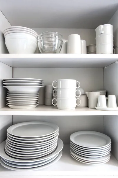 Белый шкаф с белой посудой на кухне, различные чистые блюда — стоковое фото