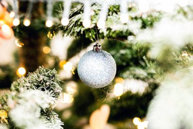 Noel ağacındaki parlak noel süslemesi karla kaplı, yakın plan.