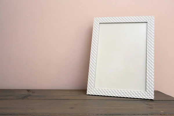 Blanco en blanco maqueta de marco de fotos en el fondo de la luz. Inicio interior, estante de madera cerca de la pared rosa — Foto de Stock