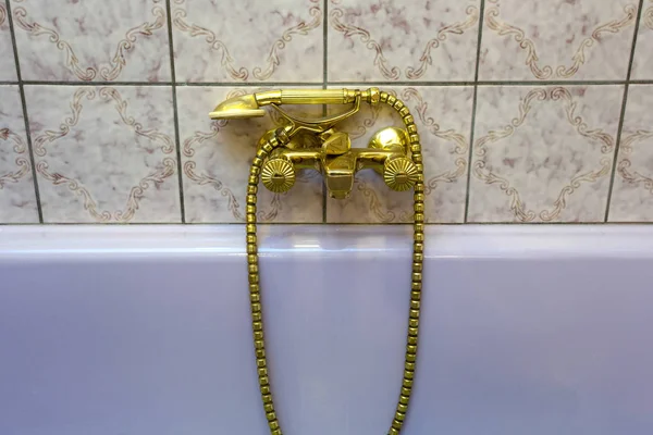 Rubinetto da bagno in oro vintage e piastrelle in ceramica sullo sfondo.Aspetto in bronzo retrò. design antico — Foto Stock