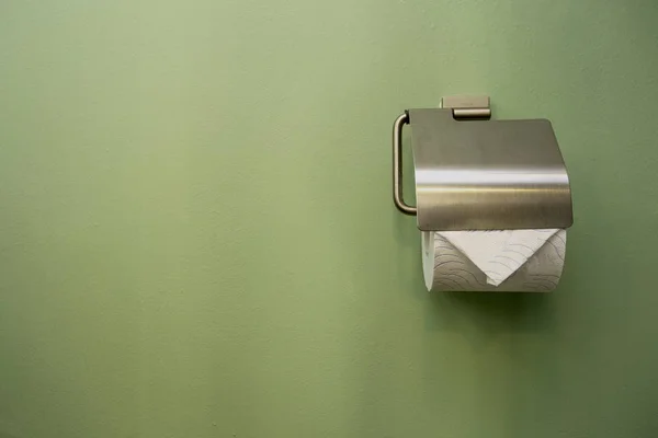 Close-up of toilet roll holder in bathroom near green wall — Stock Photo, Image