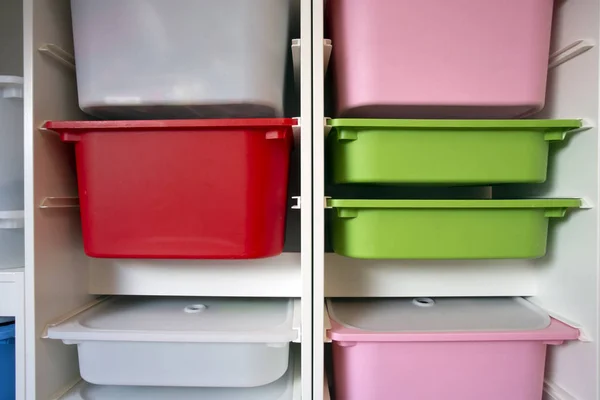 Stack of plastic storage boxes in different colors, sorting system arrangement — Stock Photo, Image