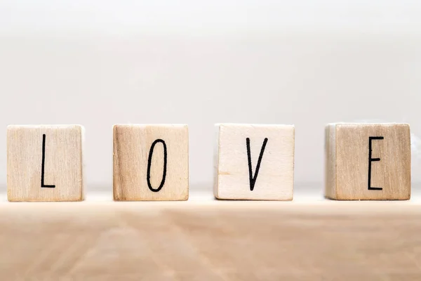 Parola Amore su cubi di legno con cuore rosso, primo piano vicino sfondo bianco — Foto Stock