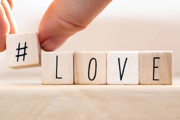 Word Love on wooden cubes with Hashtag, close-up near white background — ストック写真