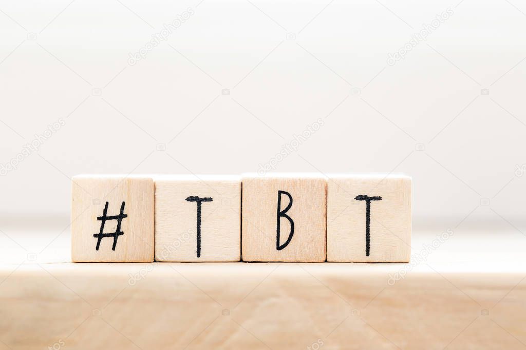 Wooden cubes with Hashtag tbt, meaning Throwback Thursday near white background social media concept