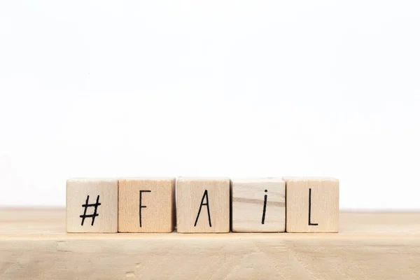 Cubi di legno con un hashtag e la parola fallire vicino a sfondo bianco, design dei social media — Foto Stock