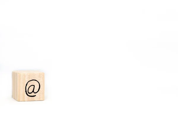 Ξύλινος κύβος με ένα εμπορικό σύμβολο At Sign απομονώνονται σε λευκό φόντο, χώρος για κείμενο — Φωτογραφία Αρχείου