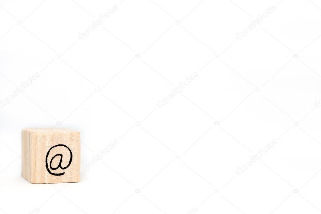 Wooden cube with a commercial At Sign symbol isolated on white background, space for text
