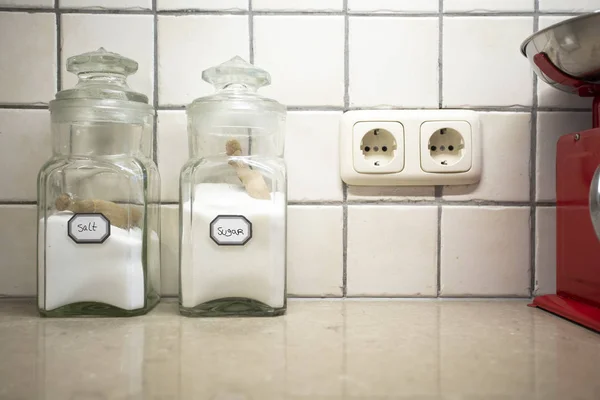 Nostálgico ainda vida da cozinha retro com dois frascos de sal e açúcar no balcão, foco seletivo no sal . — Fotografia de Stock