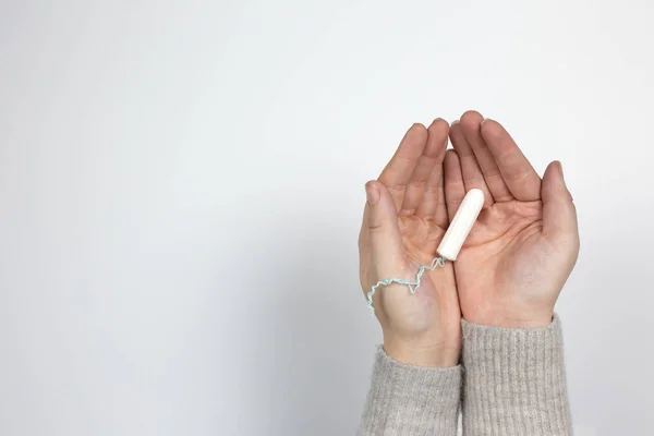 White clean tampon on womans hand isolated on a white background. Menstruation time. Hygiene and protection. — Stock Photo, Image