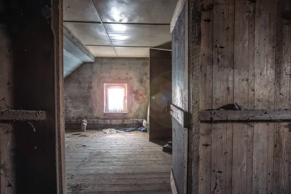 Vieux grenier en bois sombre abandonné avec lumière du soleil à travers la fenêtre et une porte ouverte, doit être rénové — Photo