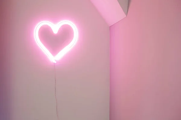 Luz de néon de coração rosa na parede em um interior moderno, conceito de Valentines design retro — Fotografia de Stock