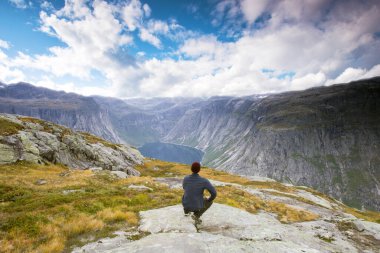 Couple tourist standing against amazing view, beautiful nature landscape hiking in Norway Trolltunga scandinavian