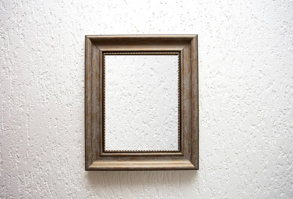 One empty wooden frame on a white wall background texture, retro modern design — Stok fotoğraf