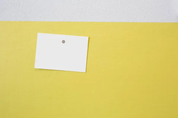 Moldura de cartão postal em branco pendurada em uma parede amarela com um empurrão, textura de fundo de concreto, espaço para texto — Fotografia de Stock